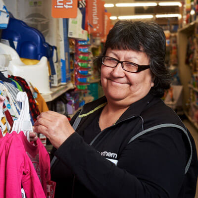 Woman middle-aged wearing a black sweater hanging clothing in a Northern Store
